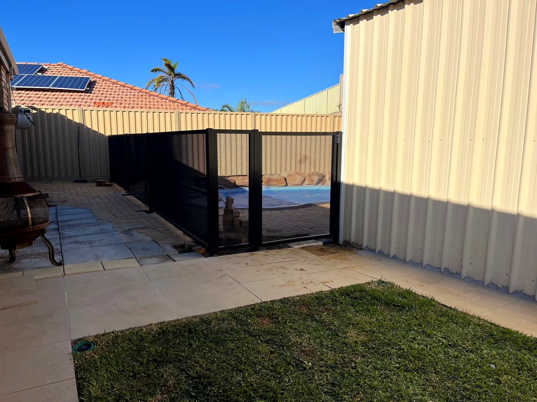 Black perforated pool fencing and gate along a side yard, Currambine WA